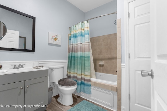 full bathroom with hardwood / wood-style floors, vanity, toilet, and shower / tub combo with curtain