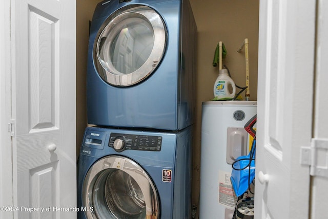 laundry area featuring stacked washer / drying machine and electric water heater