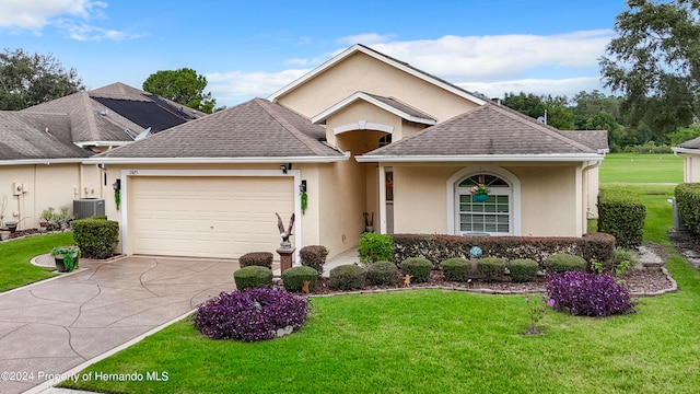 view of front of home featuring a garage, a front yard, and central AC