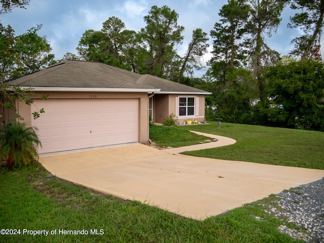 ranch-style house with a garage and a front lawn