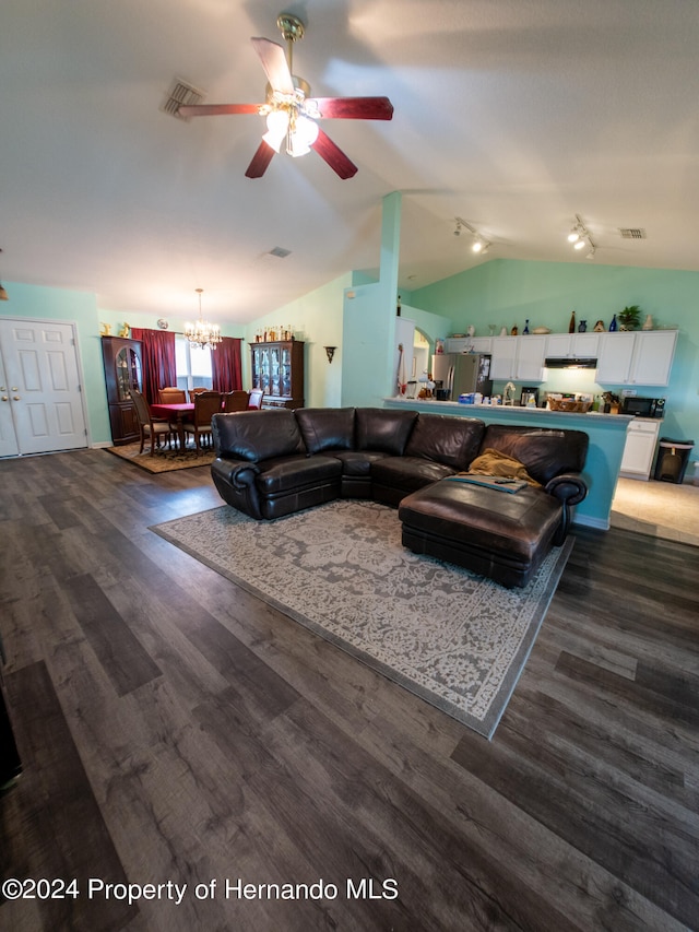 living room with dark hardwood / wood-style floors, ceiling fan with notable chandelier, and vaulted ceiling