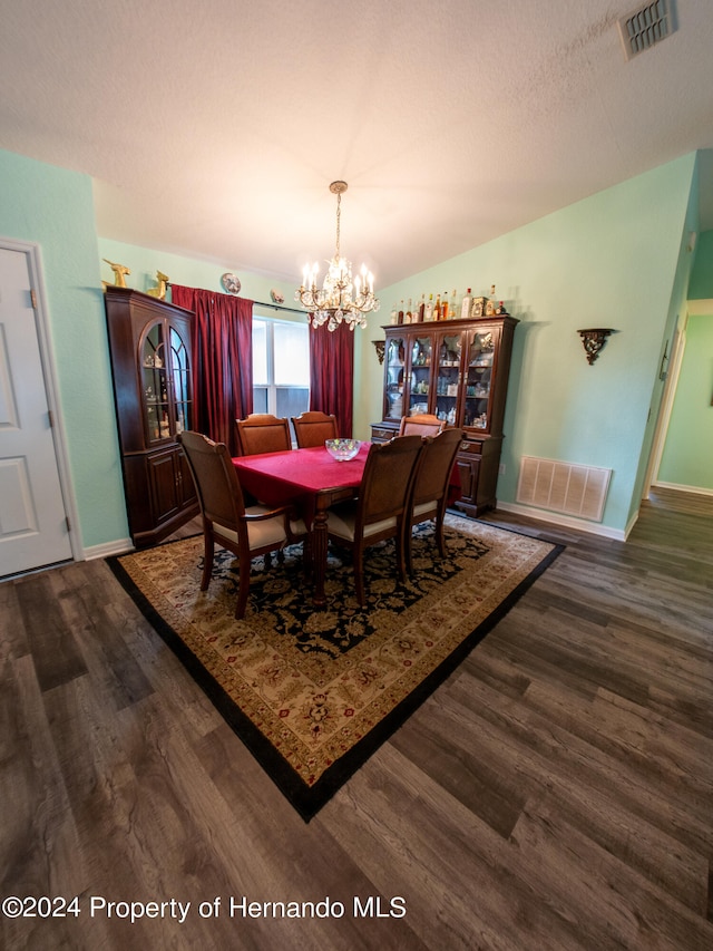 dining room with dark hardwood / wood-style flooring and a notable chandelier