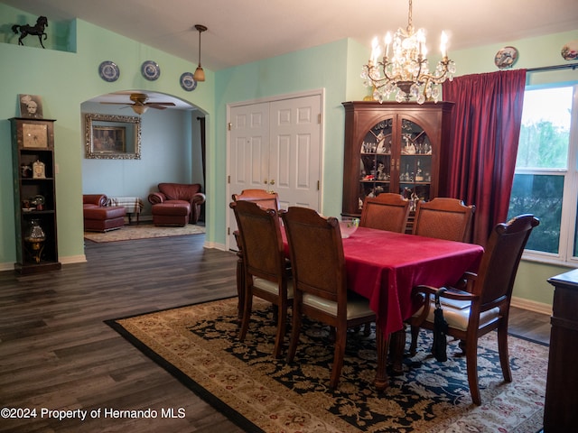 dining room with dark hardwood / wood-style flooring and ceiling fan with notable chandelier