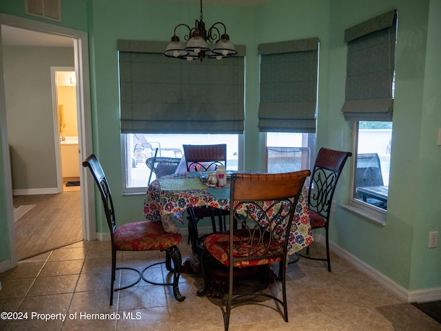 dining space featuring hardwood / wood-style floors and an inviting chandelier