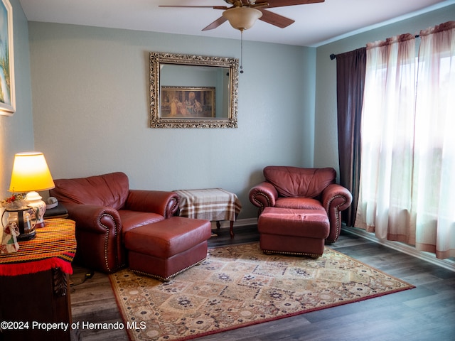 living area with hardwood / wood-style floors and ceiling fan