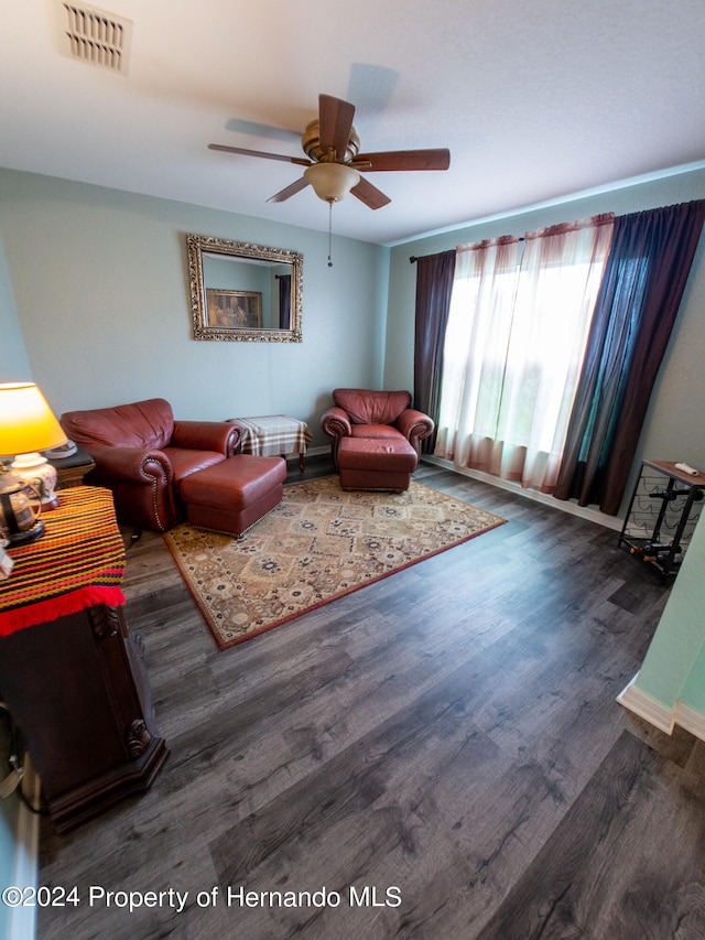 living room featuring ceiling fan and dark wood-type flooring