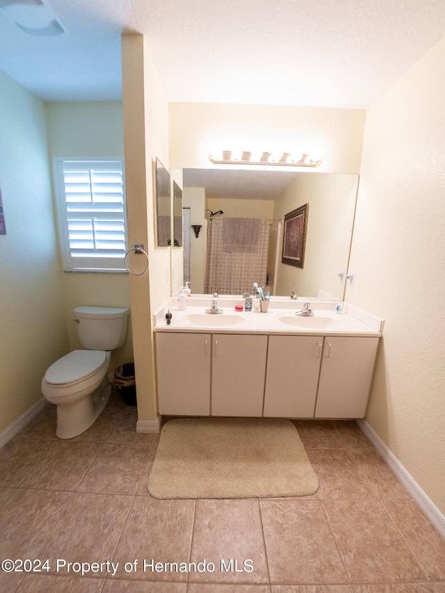 bathroom with tile patterned flooring, vanity, and toilet