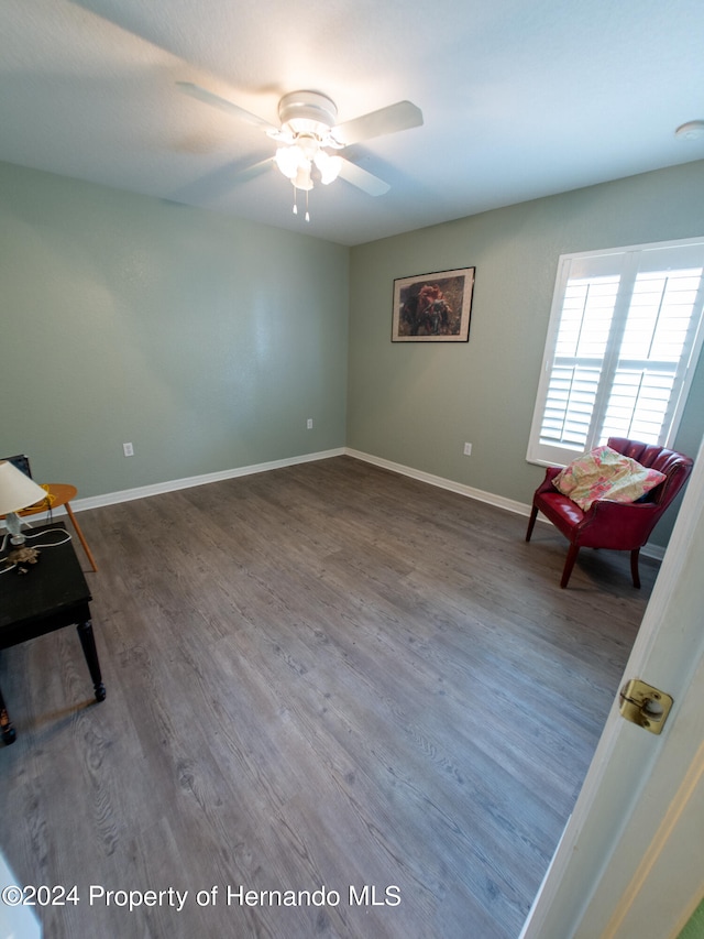 unfurnished room with ceiling fan and dark wood-type flooring