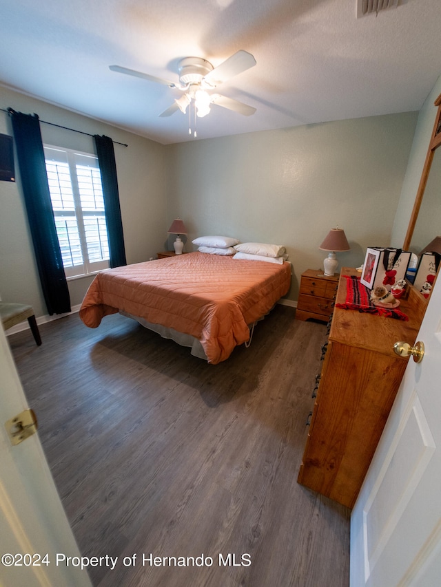 bedroom with ceiling fan and dark hardwood / wood-style flooring