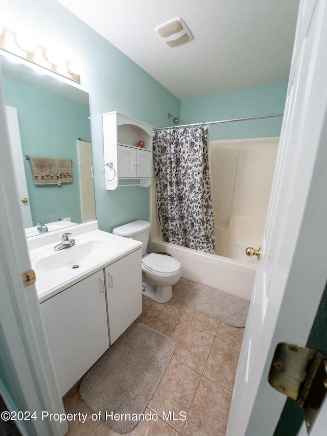 full bathroom featuring tile patterned flooring, a textured ceiling, toilet, shower / tub combo with curtain, and vanity