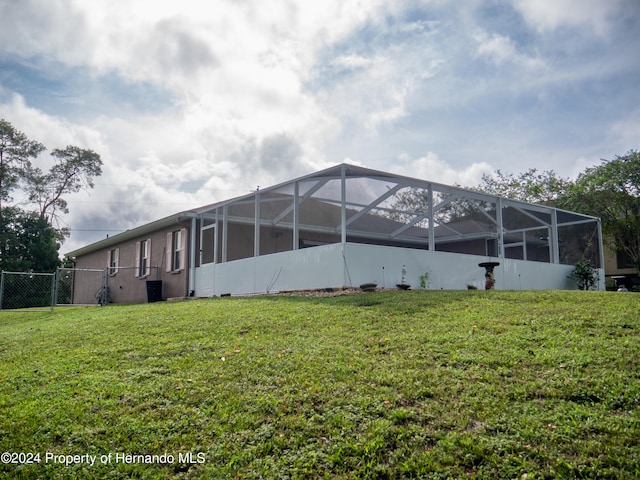 exterior space with a lanai and a yard