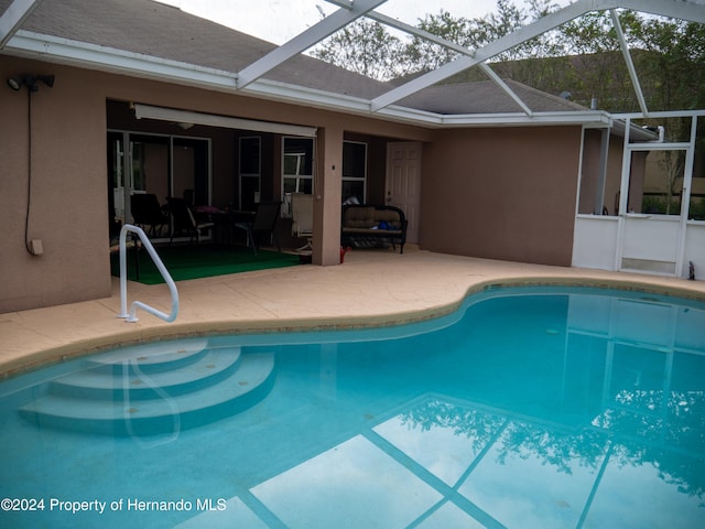 view of swimming pool with a patio and glass enclosure