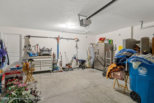 garage featuring a garage door opener and stainless steel refrigerator with ice dispenser