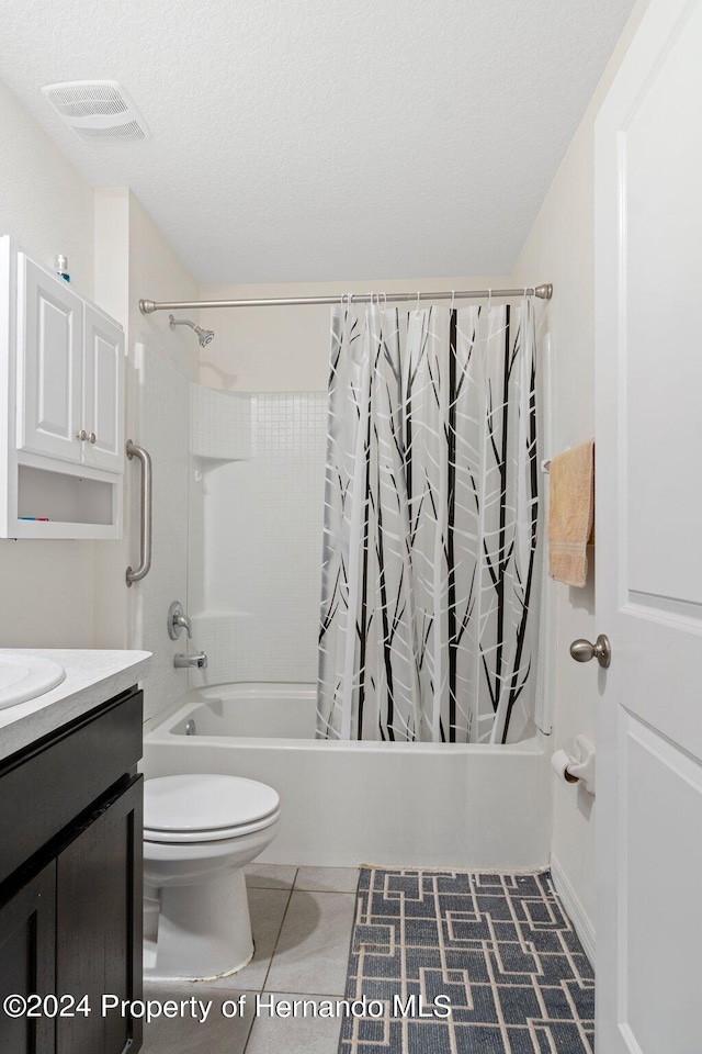 full bathroom featuring a textured ceiling, shower / tub combo with curtain, vanity, tile patterned floors, and toilet