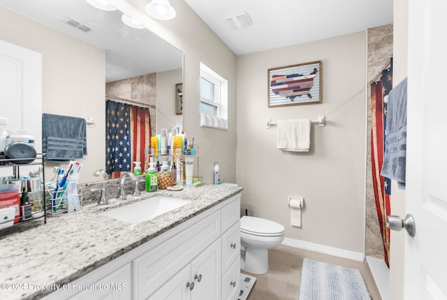 bathroom featuring curtained shower, tile patterned flooring, vanity, and toilet