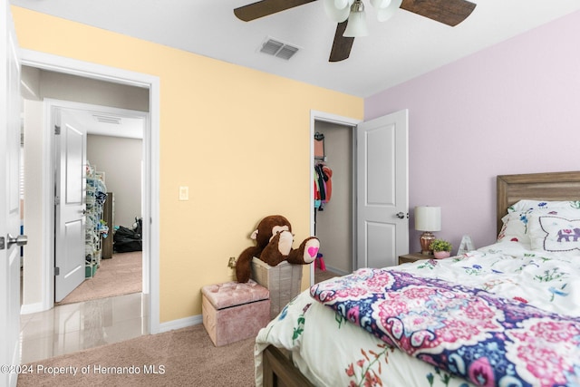 bedroom with a closet, light carpet, and ceiling fan