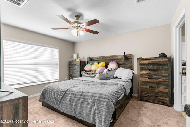 carpeted bedroom featuring a textured ceiling and ceiling fan