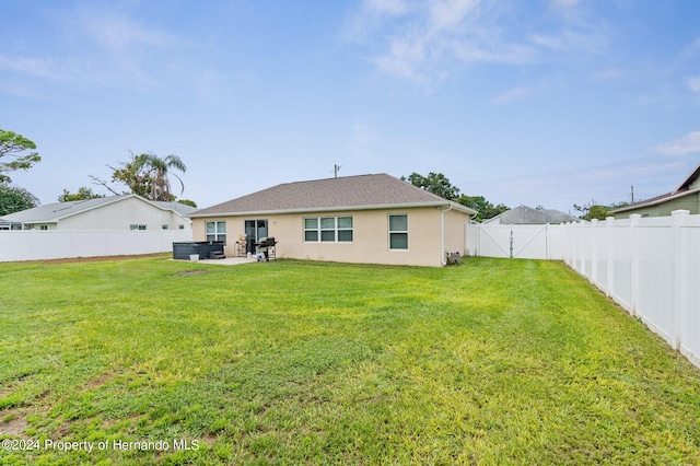 back of property featuring a patio area and a yard