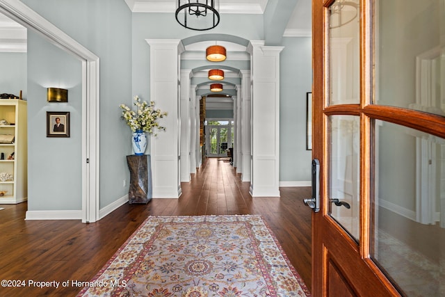 entryway with ornamental molding and dark hardwood / wood-style floors