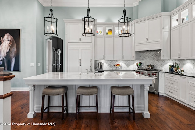 kitchen featuring high quality appliances, a center island with sink, dark hardwood / wood-style flooring, and ornamental molding