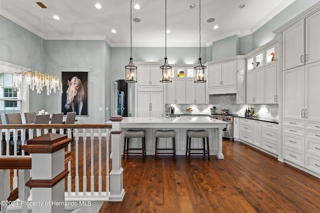 kitchen featuring high end stove, dark wood-type flooring, decorative light fixtures, and white cabinets