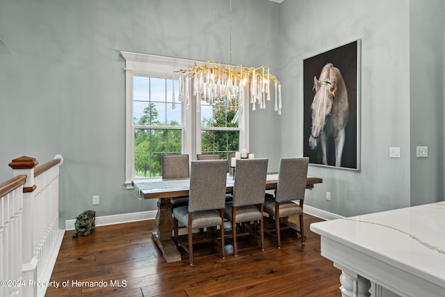 dining area with dark wood-type flooring, a healthy amount of sunlight, and a notable chandelier