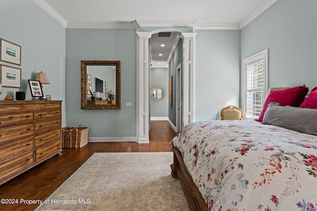 bedroom with dark hardwood / wood-style flooring, crown molding, and decorative columns