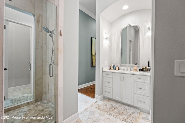 bathroom featuring walk in shower, vanity, tile patterned floors, and crown molding