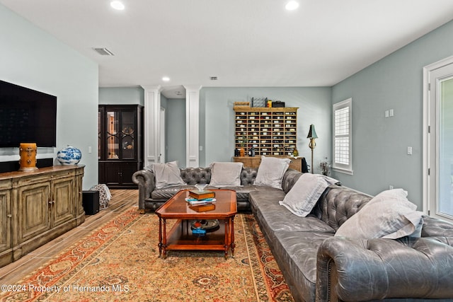 living room featuring decorative columns and hardwood / wood-style floors