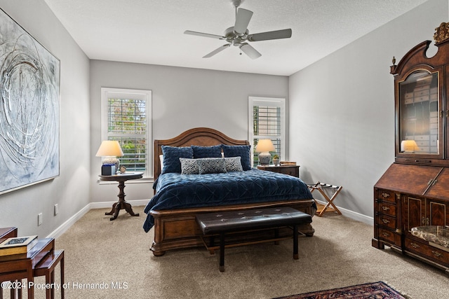 bedroom featuring ceiling fan, a textured ceiling, and carpet floors