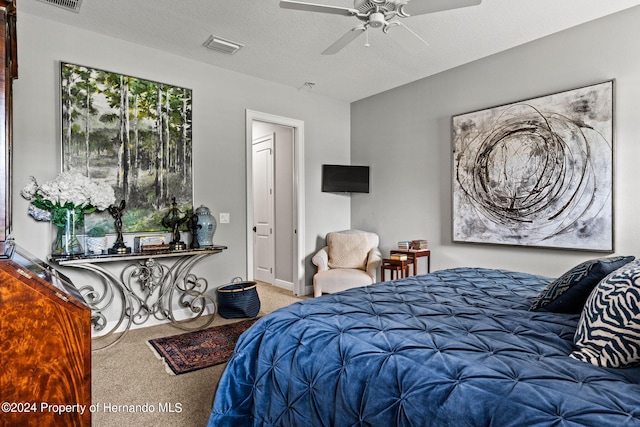 bedroom featuring a textured ceiling, ceiling fan, and carpet floors