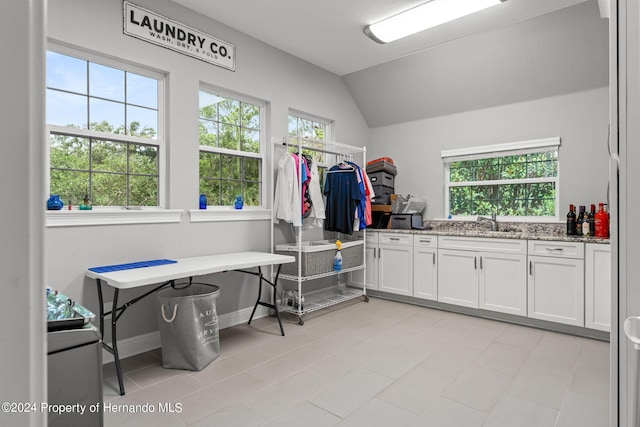 laundry room with a wealth of natural light, sink, and light tile patterned flooring