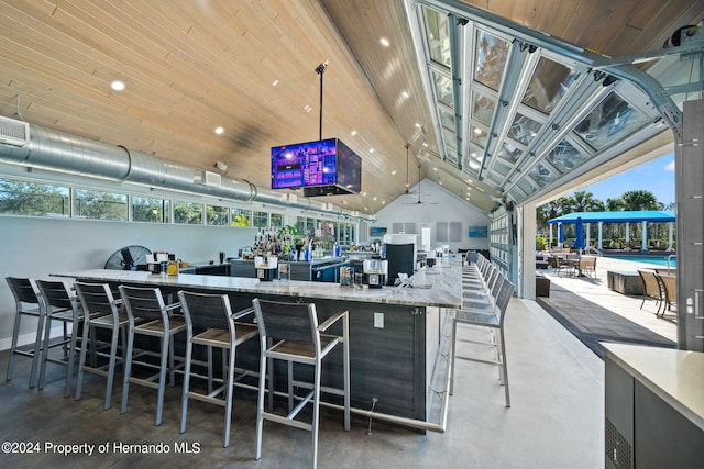 interior space featuring pendant lighting, light stone counters, wood ceiling, and concrete floors