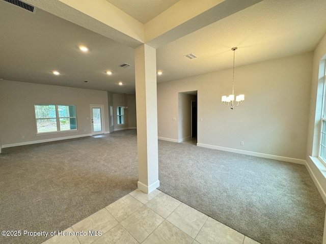 unfurnished room with light colored carpet and an inviting chandelier