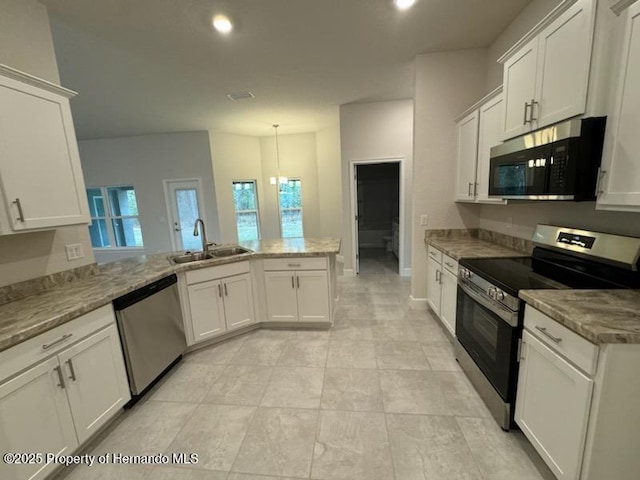 kitchen featuring light stone countertops, pendant lighting, white cabinets, appliances with stainless steel finishes, and sink