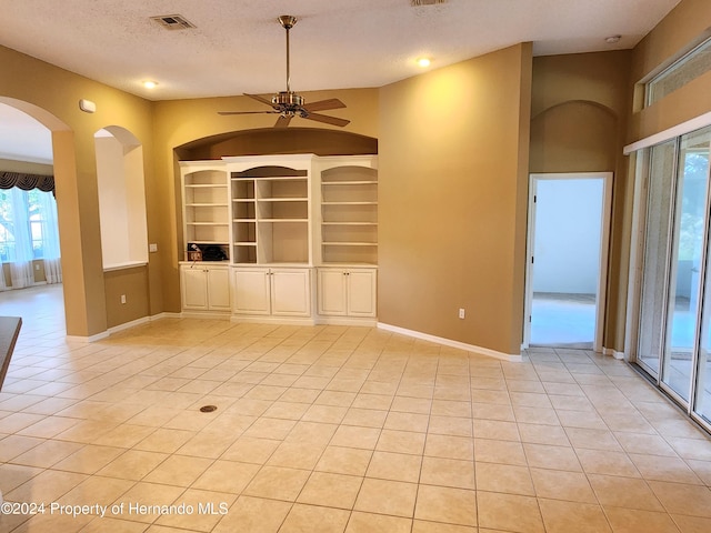 tiled empty room featuring a textured ceiling and ceiling fan