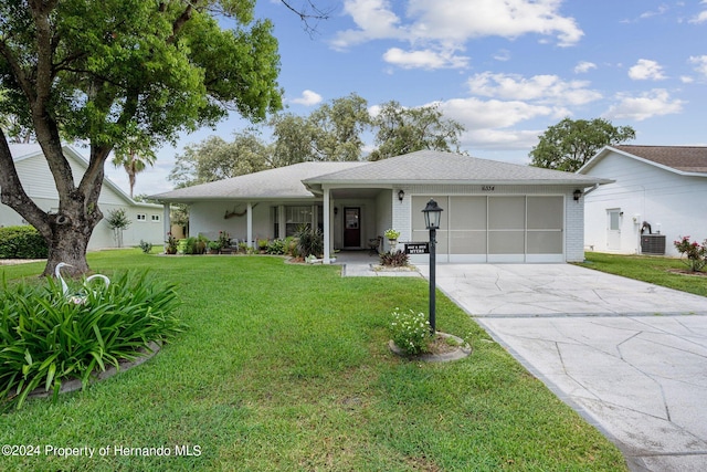 ranch-style home featuring a garage and a front lawn