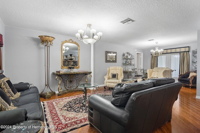 living room with a textured ceiling, an inviting chandelier, and dark hardwood / wood-style flooring