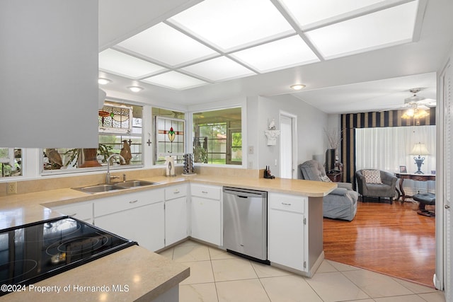 kitchen featuring kitchen peninsula, sink, stainless steel dishwasher, white cabinetry, and light hardwood / wood-style flooring