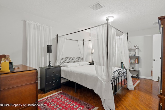 bedroom with hardwood / wood-style floors and a textured ceiling