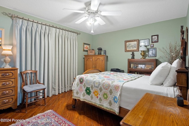 bedroom featuring hardwood / wood-style flooring, a textured ceiling, and ceiling fan