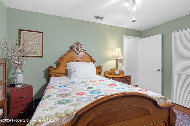 bedroom with hardwood / wood-style floors, ceiling fan, and a closet