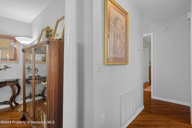 corridor with dark hardwood / wood-style flooring