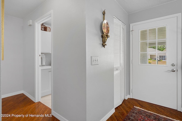 hallway with hardwood / wood-style floors and a textured ceiling