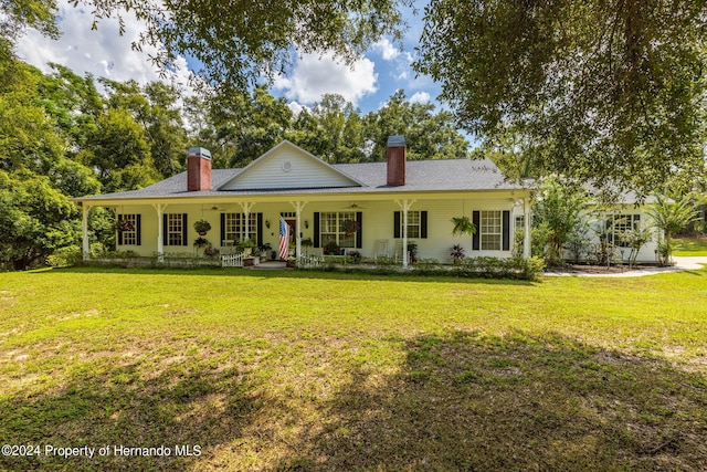 back of house featuring a lawn and covered porch