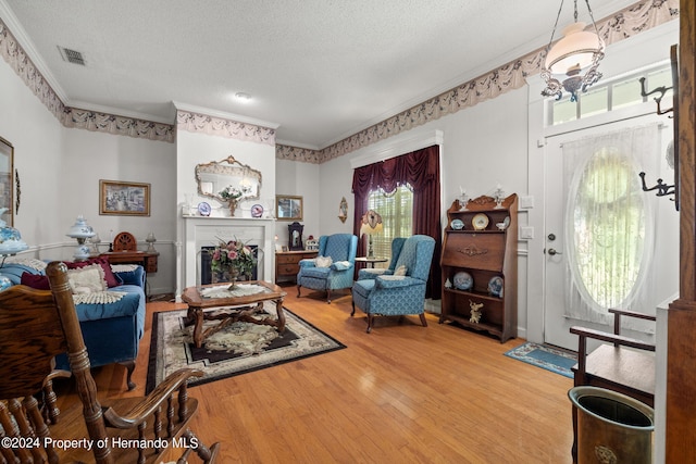 living room featuring hardwood / wood-style floors, plenty of natural light, and crown molding