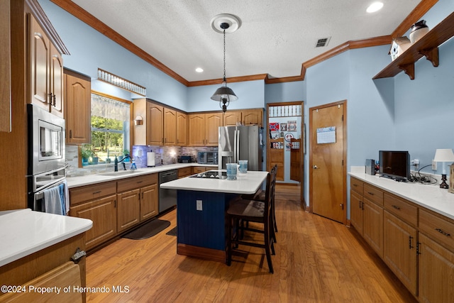 kitchen featuring black appliances, sink, an island with sink, a breakfast bar, and light hardwood / wood-style flooring