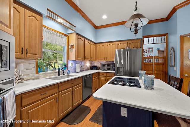 kitchen featuring black appliances, ornamental molding, a kitchen island, sink, and light hardwood / wood-style floors