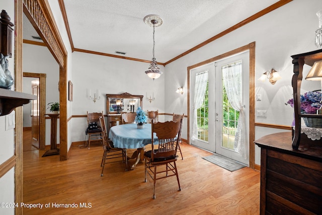 dining area with crown molding, french doors, light hardwood / wood-style floors, and a textured ceiling