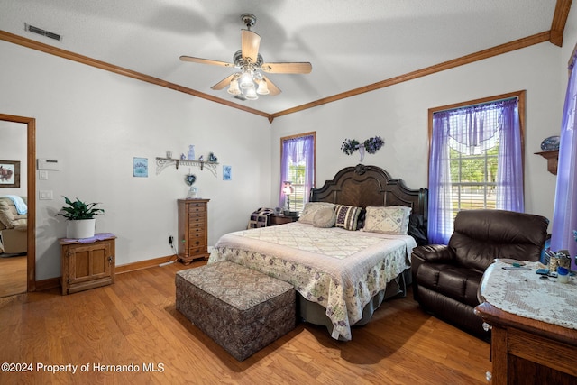 bedroom featuring ornamental molding, multiple windows, ceiling fan, and light hardwood / wood-style flooring